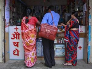 A medical representative with Abbott talks to a chemist at a market in Pune